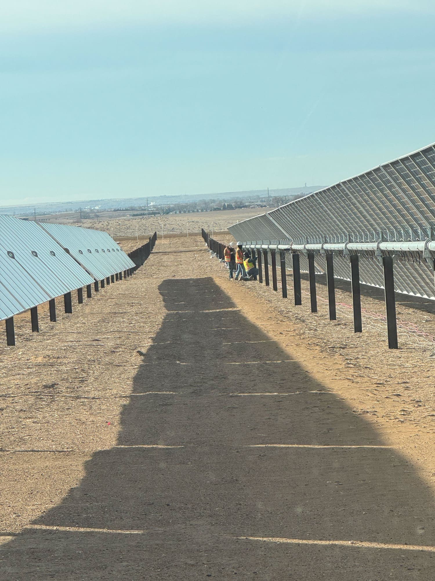 Road running between rows of installed solar panels