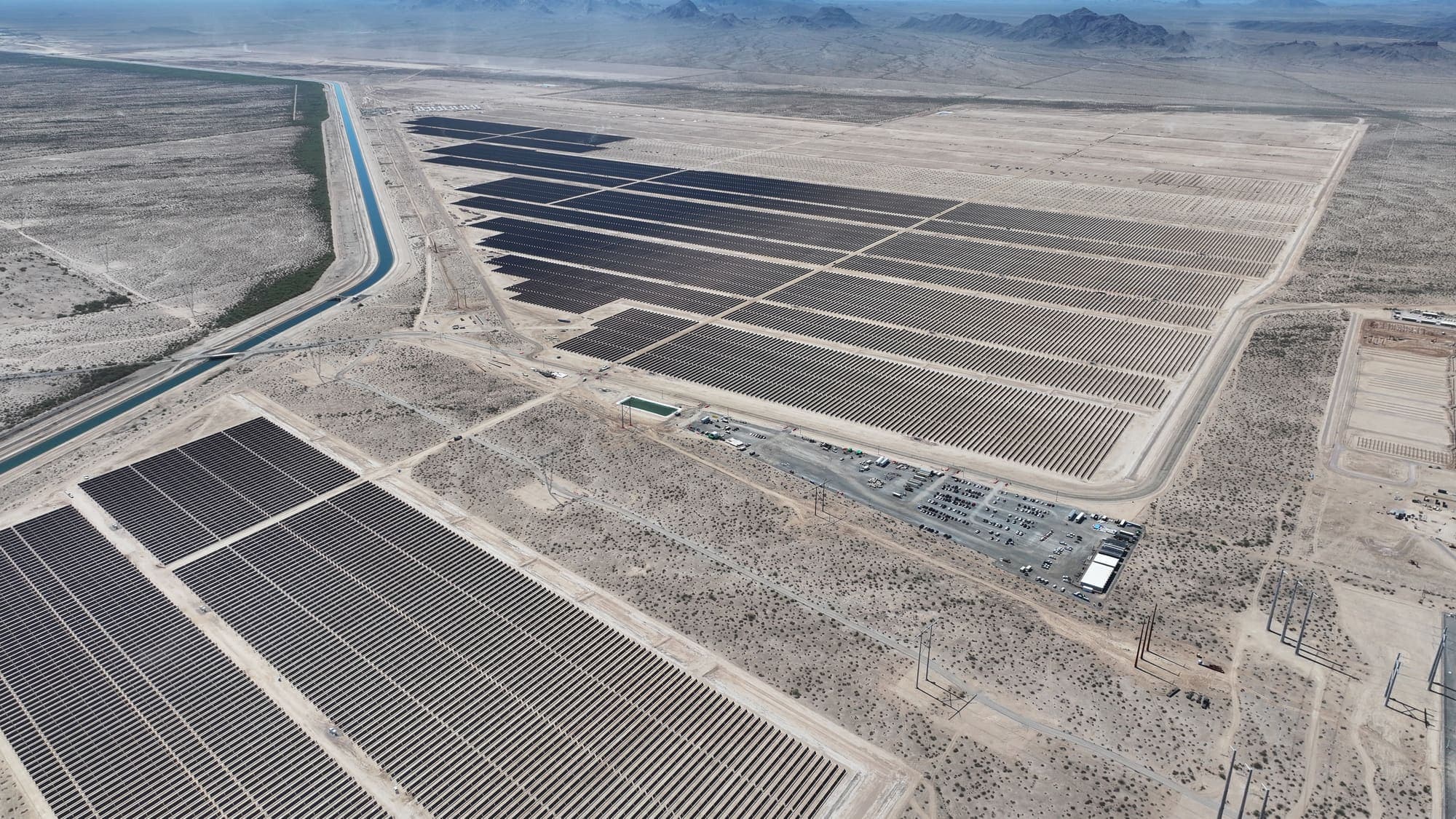 Aerial view of solar arrays beside a canal in the Arizona desert