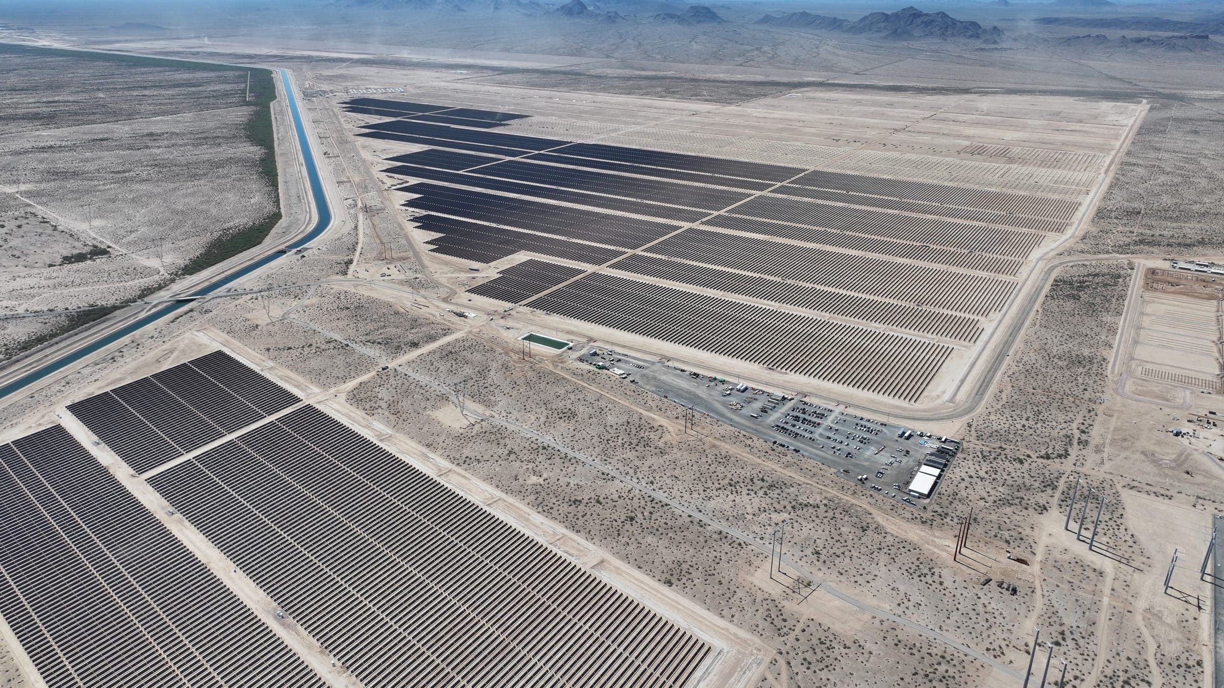 Aerial view of solar arrays beside a canal in the Arizona desert