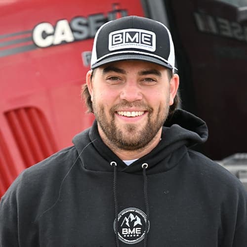 Brodie Wolfe, Controller, in a BME cap in front of a red tractor